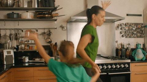 Mamá e hijo bailando felices en la cocina
